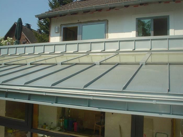 Ein Haus mit einem Metalldach und einem großen Fenster