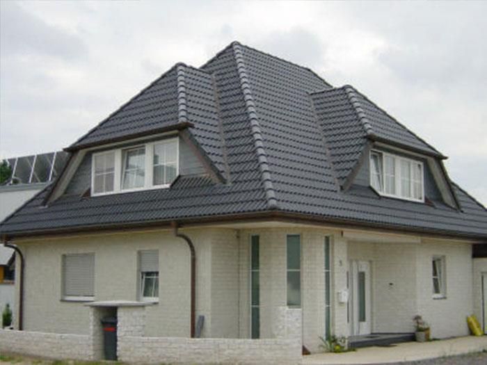 Ein weißes Haus mit einem schwarzen Ziegeldach