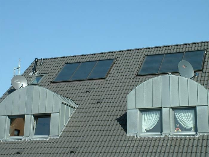 Ein Dach mit Sonnenkollektoren und Satellitenschüsseln darauf