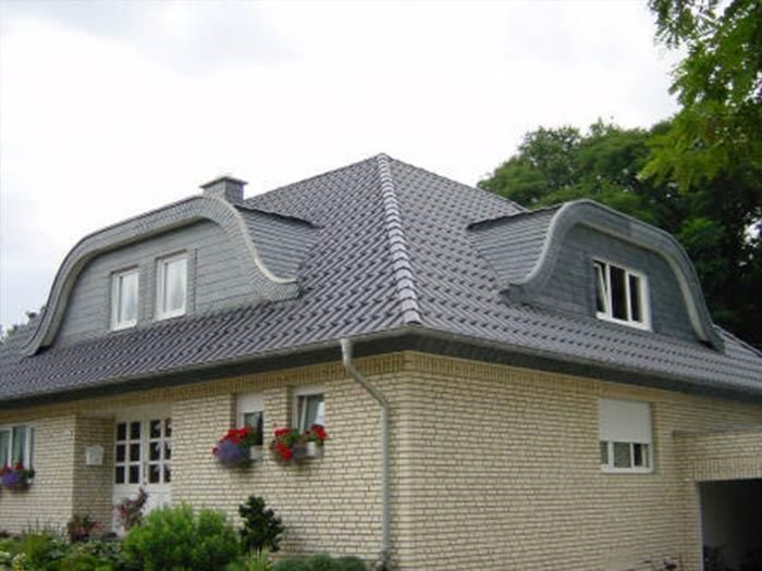 Ein weißes Backsteinhaus mit einem grauen Dach