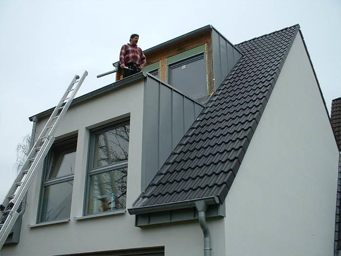 Ein Mann steht auf dem Dach eines Hauses