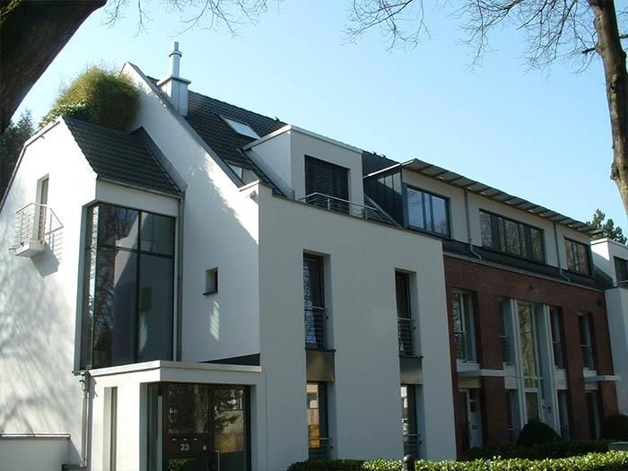 Ein weißes Gebäude mit einem Dach, auf dem sich ein Schornstein befindet
