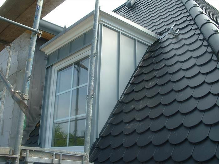 Ein Dach mit Fenster und davor ein Gerüst