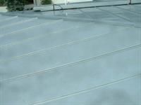 Eine Nahaufnahme eines Betonbodens mit einem Dach im Hintergrund.