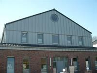 Ein großes Gebäude mit einem Dach, das wie eine Scheune aussieht.