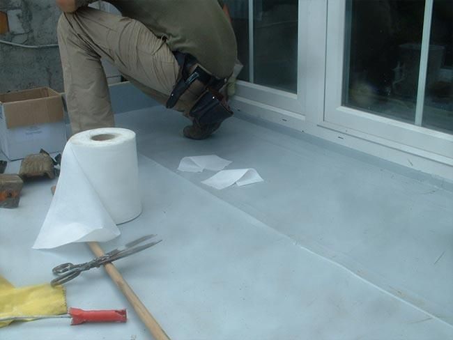 Ein Mann kniet neben einer Rolle Toilettenpapier