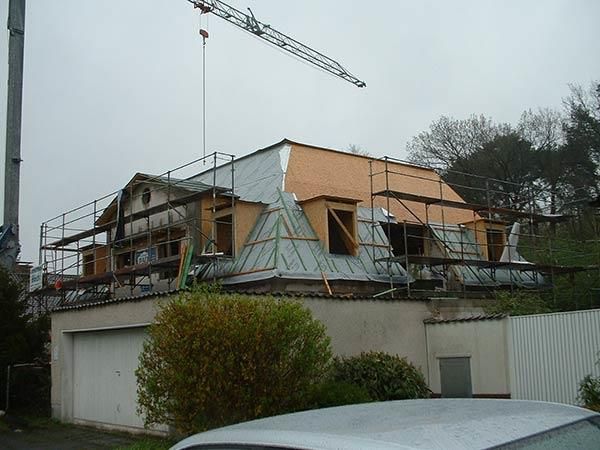 Ein Auto steht vor einem im Bau befindlichen Gebäude