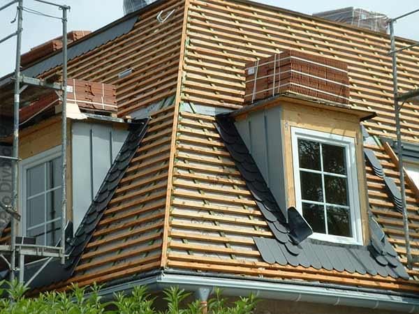 Ein Haus mit Holzdach und Fenster ist im Bau.