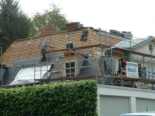 Ein Mann arbeitet auf dem Dach eines Hauses.