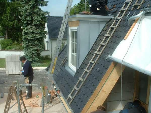 Ein Mann arbeitet auf dem Dach eines Hauses