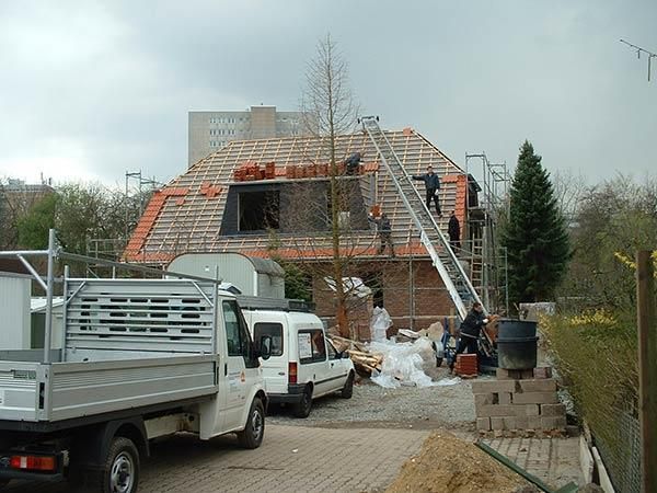 Ein weißer LKW steht vor einem im Bau befindlichen Gebäude