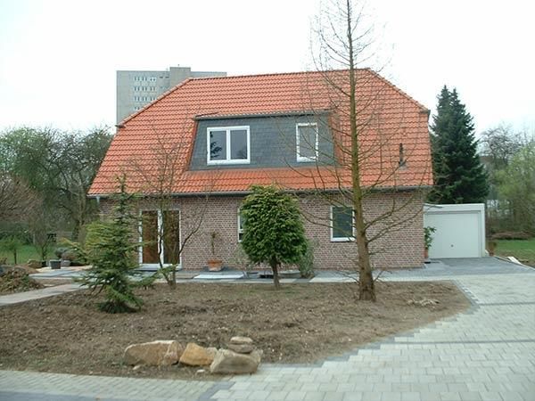 Ein Backsteinhaus mit rotem Ziegeldach und einer Garage