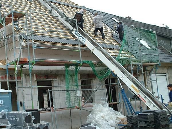 Bauarbeiter arbeiten auf dem Dach eines Gebäudes