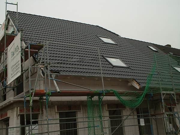 Ein im Bau befindliches Gebäude mit Gerüst und einem Dach mit Oberlichtern