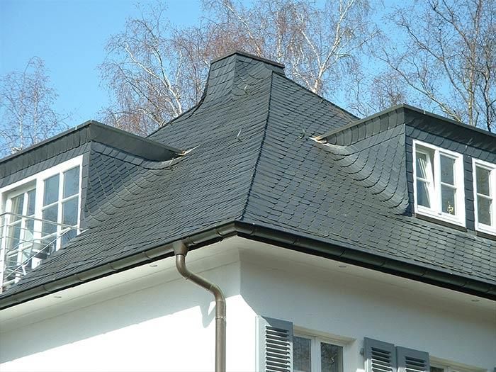 Ein weißes Haus mit einem schwarzen Dach und zwei Fenstern