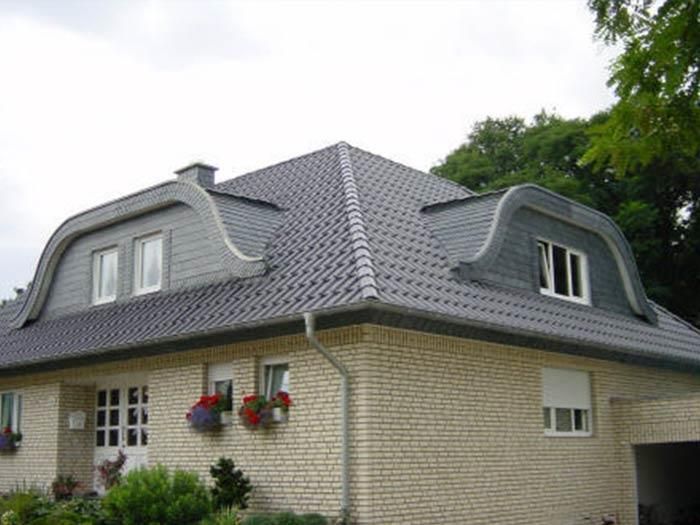 Ein weißes Backsteinhaus mit einem grauen Dach