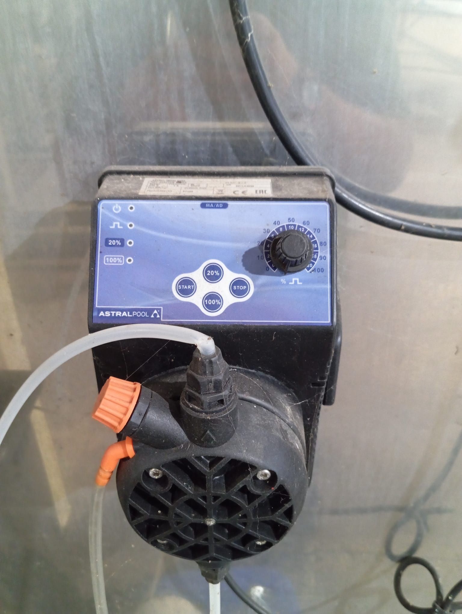 Una bomba con una manguera conectada a ella está sobre una mesa.