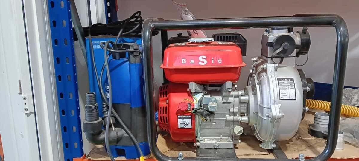 Una bomba de agua roja y blanca está colocada encima de un estante de madera.