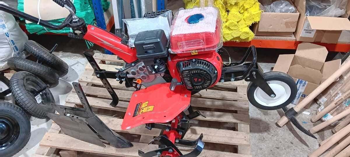 Un tractor rojo está sentado encima de un palé de madera.