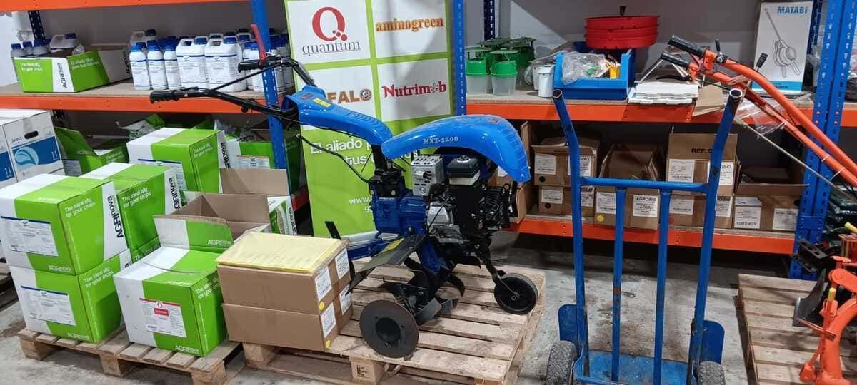 Un pequeño tractor está sentado sobre una paleta en un almacén.