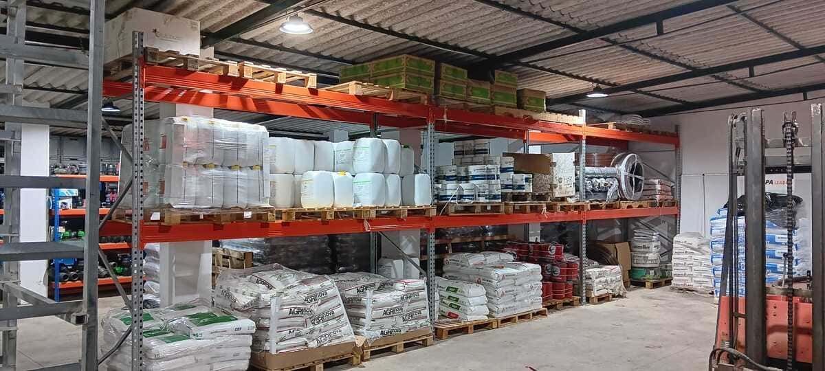 Un gran almacén lleno de montones de paletas y estantes.