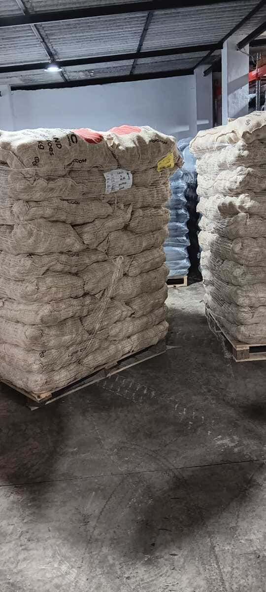 Hay muchas bolsas apiladas una encima de otra en un almacén.