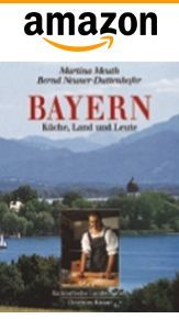 Buchcover: „Bayern“ mit See- und Bergblick, Person beim Kochen, Amazon-Logo.