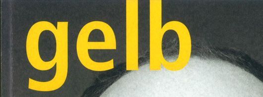 Gelbes Wort „Gelb“ über dem Gesicht einer Person auf dunklem Hintergrund.