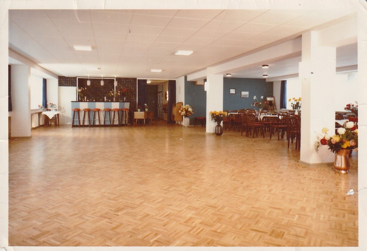 Ein großer Raum mit Holzboden und einer Bar