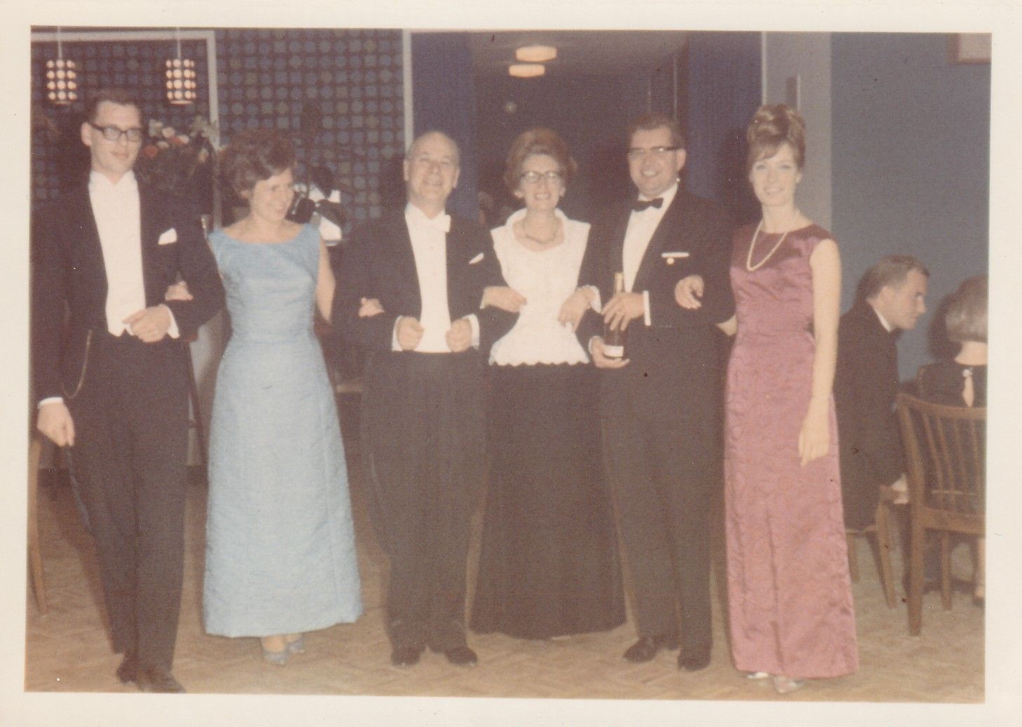 Eine Gruppe von Menschen in Smokings und Kleidern posiert für ein Foto