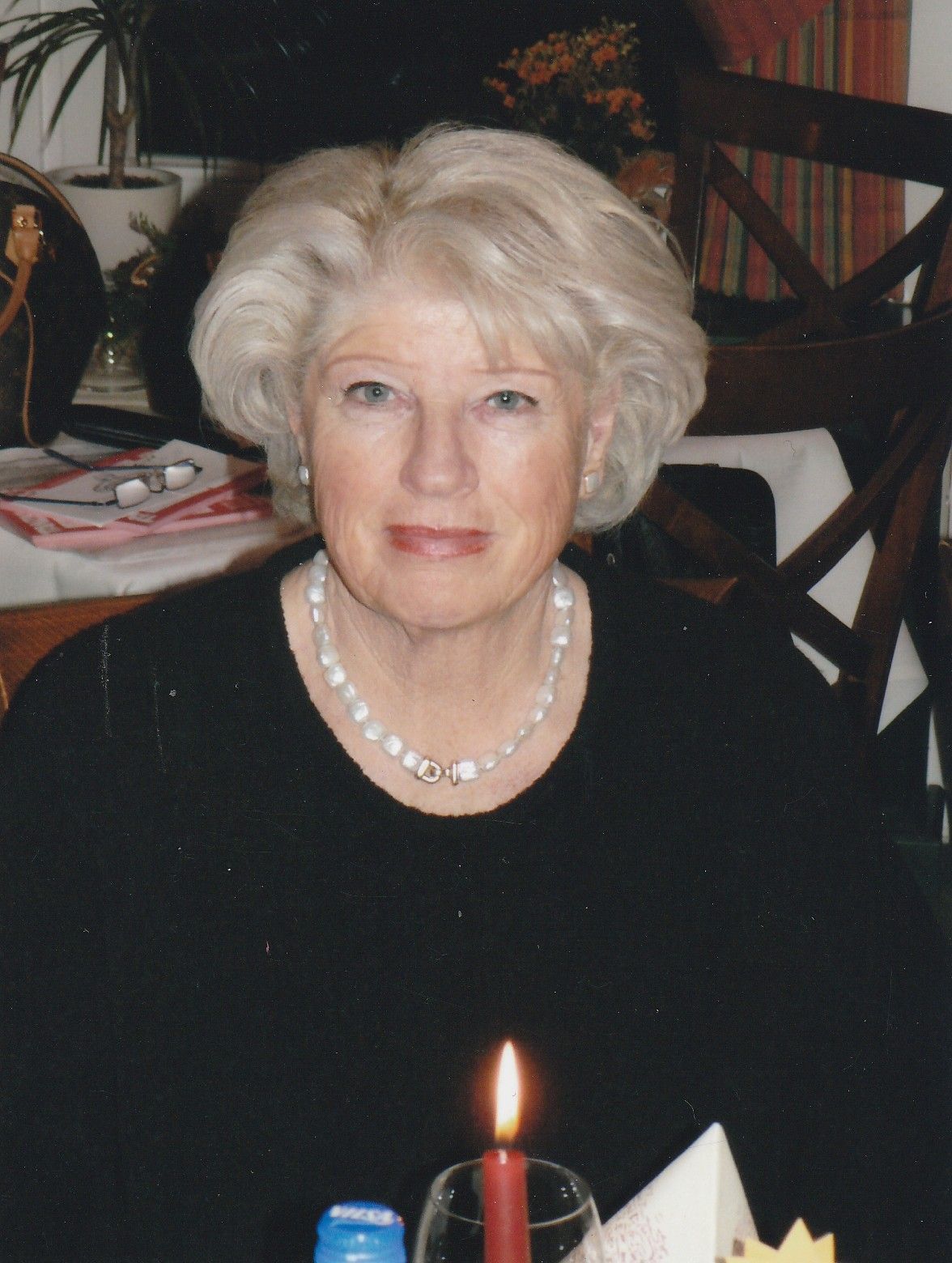 Eine Frau sitzt an einem Tisch mit einer Kerze vor ihr