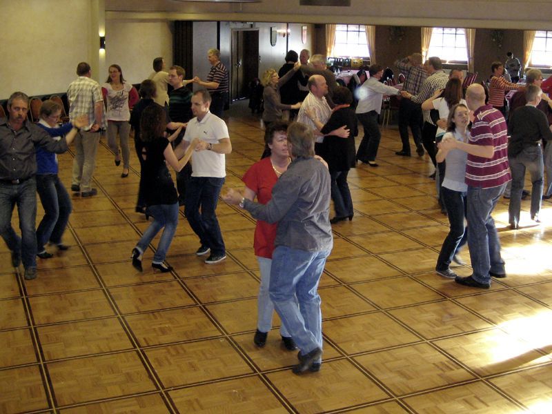 Eine Gruppe von Menschen tanzt in einem großen Raum