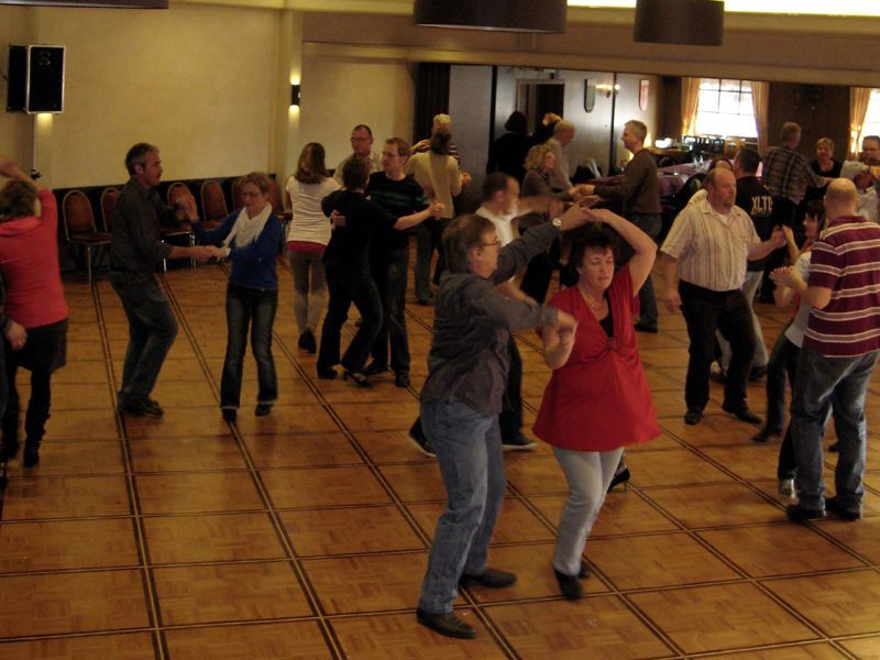 Eine Gruppe von Menschen tanzt in einem großen Raum