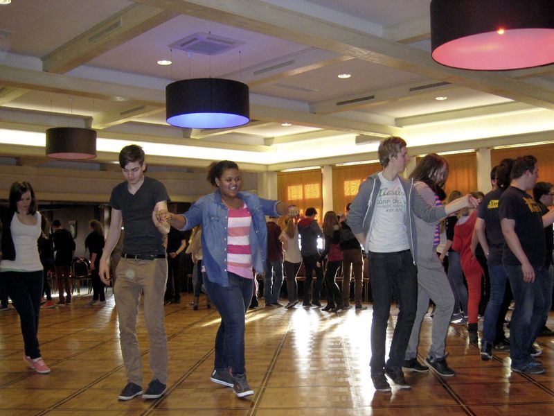 Eine Gruppe von Menschen tanzt in einem großen Raum