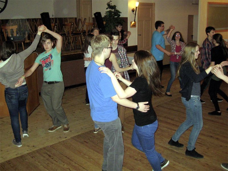 Eine Gruppe junger Leute tanzt in einem Raum