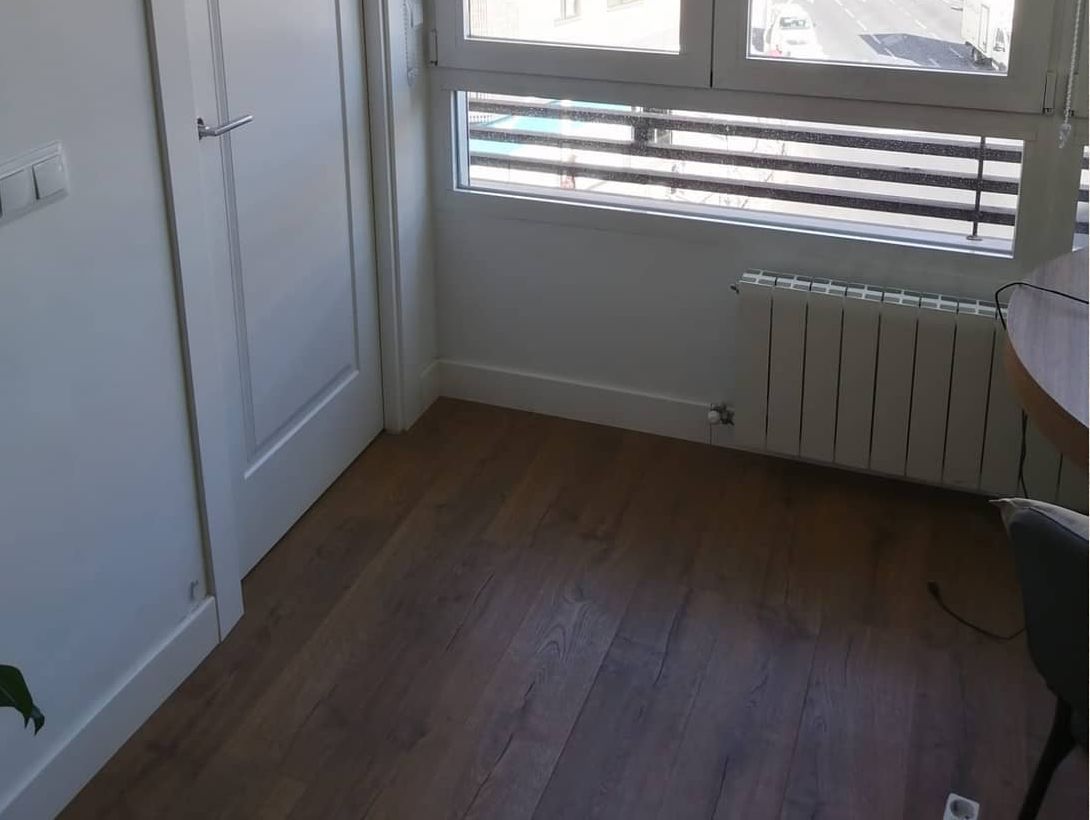 Una habitación con una mesa y sillas y un radiador.