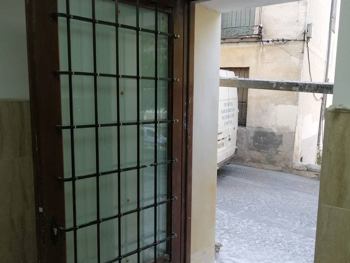 Una puerta con rejas da a un callejón estrecho.