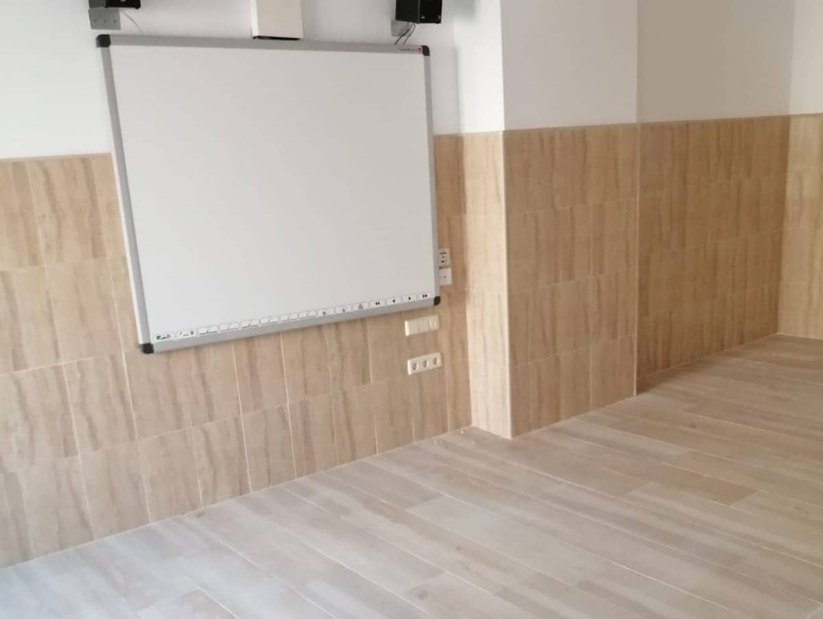 Una habitación con una pizarra en la pared y un piso de madera.