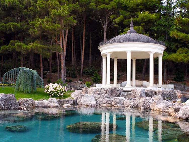 Hay un mirador en medio de un estanque en medio de un bosque.