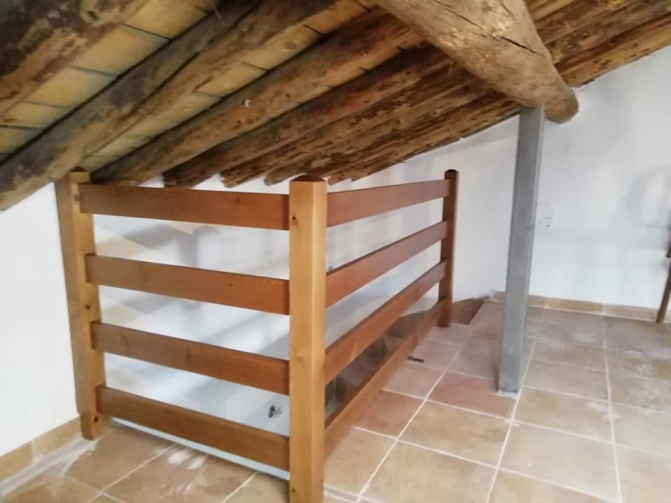 Una barandilla de madera en una habitación con techo