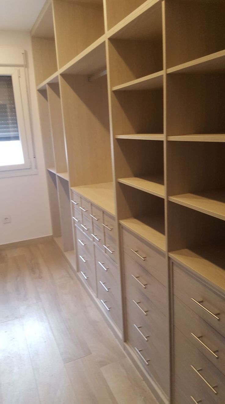 Un vestidor con muchos estantes y cajones.