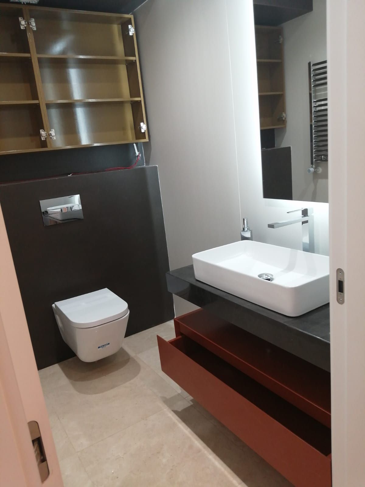 Un baño con inodoro, lavabo y espejo.