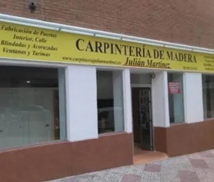 Un edificio con un cartel amarillo que dice carpintería de madera.