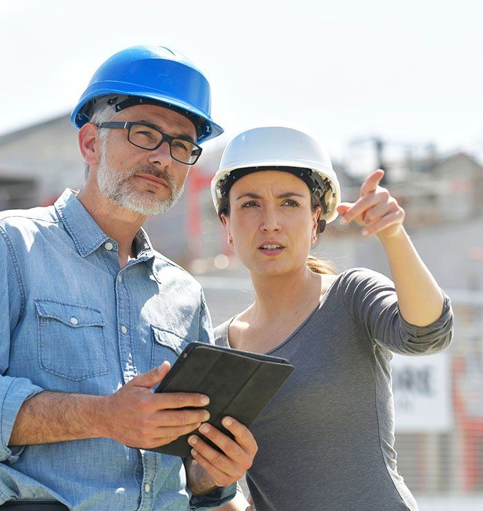 Un homme et une femme sur un chantier en train de superviser les travaux