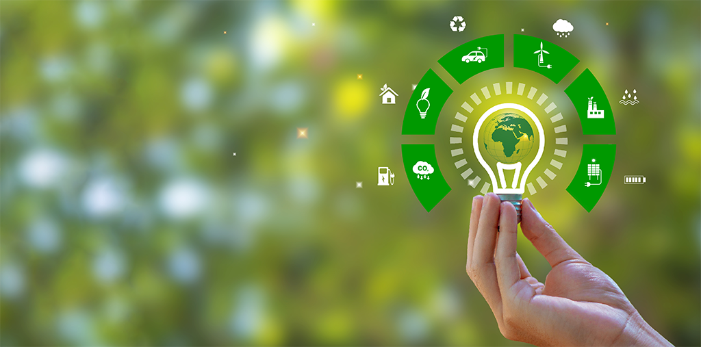 Une main tenant une ampoule et une carte du monde verte avec des icônes sources d'énergie pour un développement renouvelable et durable