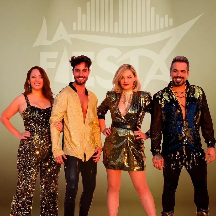 Cuatro personas con trajes brillantes, sonriendo. El logo de 