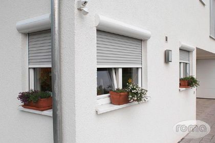 Ein weißes Gebäude mit zwei Fenstern mit Fensterläden