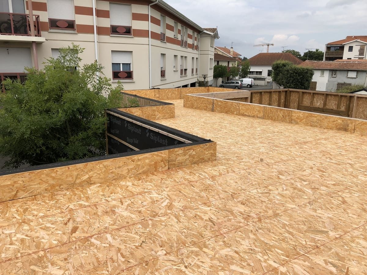 Toit terrasse en construction avec panneaux de bois