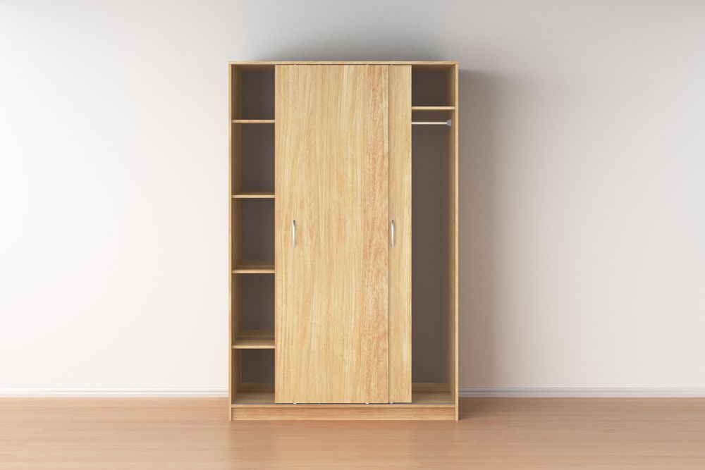 Un armario de madera vacío con puertas correderas en una habitación vacía.