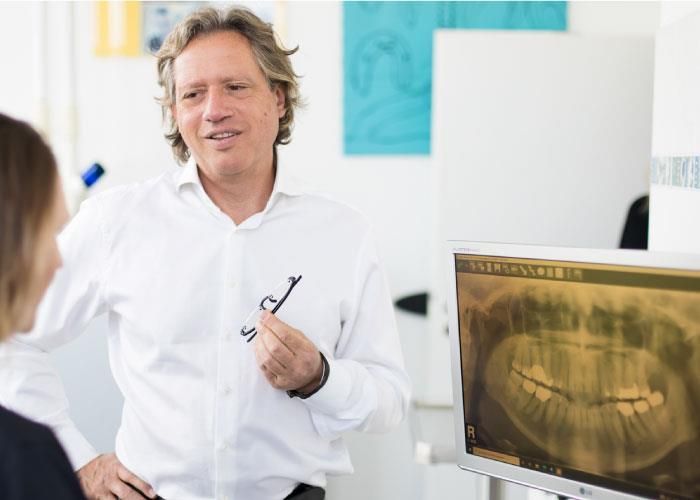 Ein Mann spricht mit einer Frau vor einem Computerbildschirm.